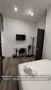 a bedroom with a bed and a desk with a television at Chueca Rooms Madrid in Madrid