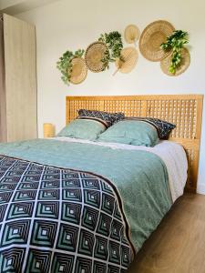 sypialnia z łóżkiem z drewnianym zagłówkiem w obiekcie Le gîte de Mireloup w mieście Plerguer