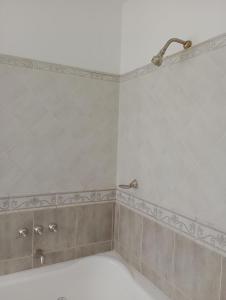 y baño con ducha con cabezal de ducha. en Nueva Morada en Córdoba