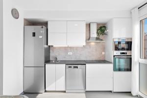 a white kitchen with white cabinets and appliances at MEDANO4YOU Casa La Barca Sur in El Médano