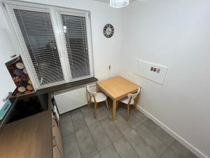 una pequeña cocina con una mesa y un reloj en la pared en Apartament Chopina 25 en Lublin