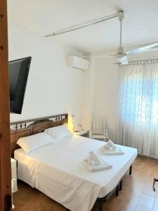 una camera da letto con un letto bianco e asciugamani di Porto Istana's house a Porto Istana