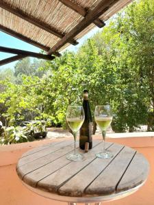 two glasses of white wine sitting on a wooden table at Porto Istana's house in Porto Istana