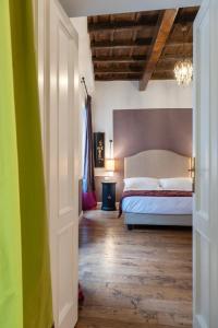 Residenza Clodio Spanish Steps في روما: غرفة نوم بسرير ابيض وارضية خشبية