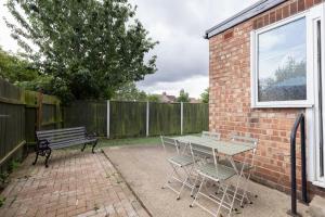 a patio with a table and chairs and a bench at Properties Unique Cleveland House in Stockton-on-Tees