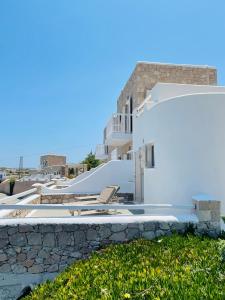 a white house with white walls and a yard at Milo Milo Suites in Mandrakia