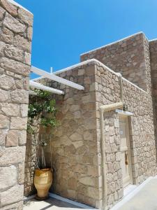 a stone house with a potted plant on the side of it at Milo Milo Suites in Mandrakia