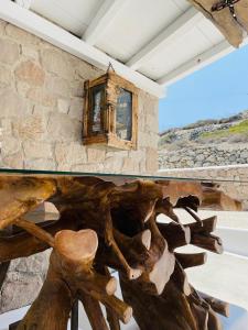 a wooden table in front of a stone wall at Milo Milo Suites in Mandrakia