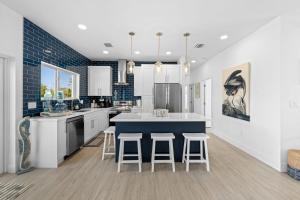 a kitchen with a blue counter and stools in it at Blue Pearl New Waterfront Haven with Heated Pool ,70 Foot Dock, and More! in Marathon