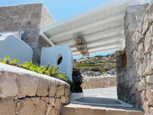 a staircase leading to a house with a stone wall at Milo Milo Suites in Mandrakia