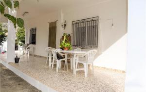 una sala da pranzo bianca con sedie bianche e tavolo di 2 Bedroom Awesome Home In Xativa-almaseretes 