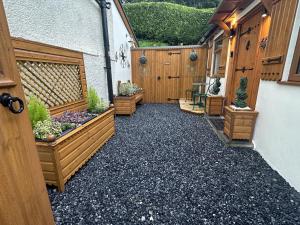 einen Innenhof mit Holzzäunen und Topfpflanzen in der Unterkunft Picton Cottage Studio - A beautiful newly refurbished annexe with handmade features in Llandowror