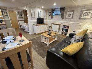ein Wohnzimmer mit Couch und Tisch in der Unterkunft Picton Cottage Studio - A beautiful newly refurbished annexe with handmade features in Llandowror + 4 Fotos