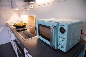 eine Mikrowelle auf einer Theke in einer Küche in der Unterkunft Stilvolles Appartement zwischen Messe und HBF in Essen