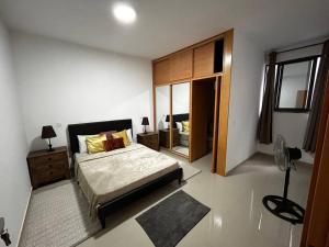 een slaapkamer met een groot bed en een spiegel bij Modern Apartment in Praia Baixo - 1 min Walking to Beach in Praia Baixo
