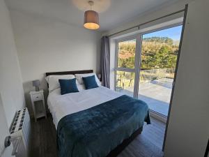 盧港的住宿－Pet Friendly Sea view Villa Millendreath Looe，一间卧室设有一张床和一个大窗户