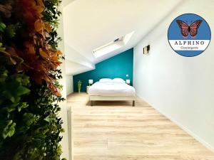 1 dormitorio con cama y pared con cartel de mariposa en Le Florissant, intime et raffiné, en Limoges