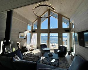sala de estar con sofá, sillas y lámpara de araña en Villa Blue Dream en Kristiansund