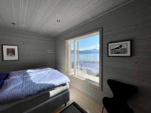a bedroom with a bed and a large window at Villa Blue Dream in Kristiansund