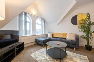 a living room with a couch and a table at The Burton- Free Gated Parking in Manchester