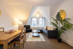 a living room with a table and a couch at The Burton- Free Gated Parking in Manchester