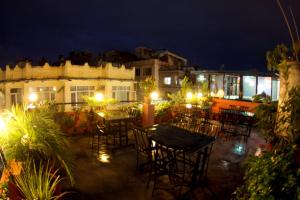 an outdoor patio with tables and chairs at night at Bag Packer's Lodge in Kathmandu