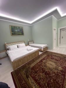 a bedroom with two beds and a rug at Tashkent hotel Parvoz in Tashkent