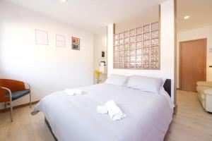 a bedroom with a white bed with two towels on it at LUMINOSO APPARTAMENTO Via MERCATO VECCHIO in Udine