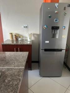 a stainless steel refrigerator in a kitchen with a counter at Cozy Farm 3BDRM 8 km ThabaBosiu in Maseru