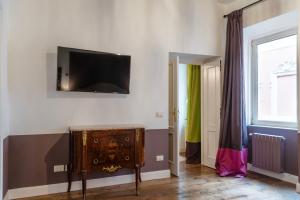 Residenza Clodio Spanish Steps في روما: غرفة مع تلفزيون على جدار مع خزانة