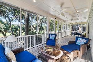 a screened in porch with chairs and a table at 7 Ocean Green in Kiawah Island