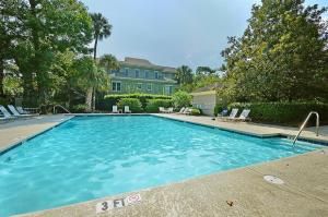 a large swimming pool with chairs and a house at 7 Ocean Green in Kiawah Island