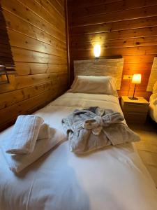 Cama en habitación con pared de madera en L'Oreneta, en Incles