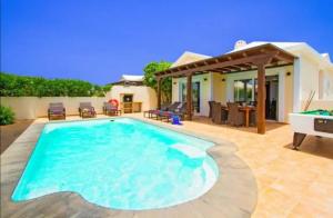 a swimming pool in the backyard of a house at Villa Mar in Playa Blanca