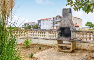 a stone oven sitting next to a white fence at Pet Friendly Apartment In Nin With Wi-fi in Nin