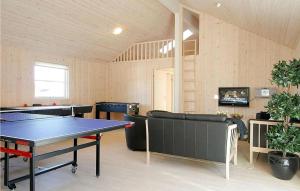 Bøtø ByにあるNice Home In Idestrup With 9 Bedrooms, Sauna And Wifiの卓球台とソファが備わる客室です。