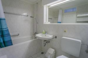a bathroom with a sink and a toilet and a mirror at Metropol-276 in Westerland +12 photos