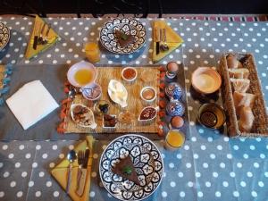 einen Tisch mit Teller mit Lebensmitteln und Tassen Orangensaft in der Unterkunft Janna d'Ifni in Sidi Ifni