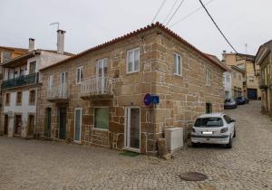 a car parked in front of a brick building at Casa da Praça de Murça in Murça