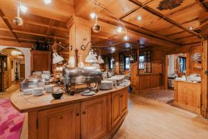 a kitchen with wooden cabinets and a counter with dishes at Dorfhotel Glücksschmiede in Saalbach Hinterglemm