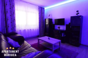 a purple room with a couch and a table at Mariuca Apartament in Buşteni