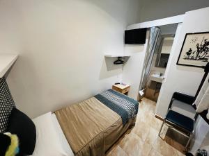 Un pequeño dormitorio con una cama y una silla. en Ciudad Condal Hostal - Paseo de Gracia, en Barcelona