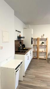 a kitchen with white cabinets and a white refrigerator at Modern Studio - perfect location in Duisburg