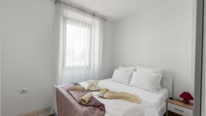 达伊拉Apartments Vorfi的白色卧室,配有带毛巾的床