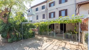 达伊拉Apartments Vorfi的一座带栅栏和树木的建筑的入口