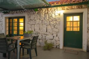 patio ze stołem i krzesłami oraz zielonymi drzwiami w obiekcie Casa Aloé Vera - Private House w/ free Breakfast w mieście Cidade Velha