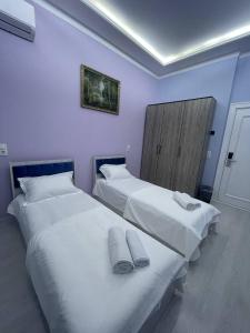two beds in a hotel room with white sheets at Tashkent hotel Parvoz in Tashkent