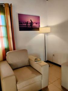 a living room with a chair and a picture on the wall at Casa Aloé Vera - Private House w/ free Breakfast in Cidade Velha