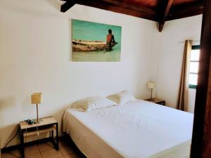 sypialnia z łóżkiem i zdjęciem mężczyzny na łodzi w obiekcie Casa Aloé Vera - Private House w/ free Breakfast w mieście Cidade Velha