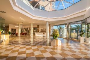 a lobby with a checkered floor and windows at Oliva Nova Beach & Golf Hotel in Oliva